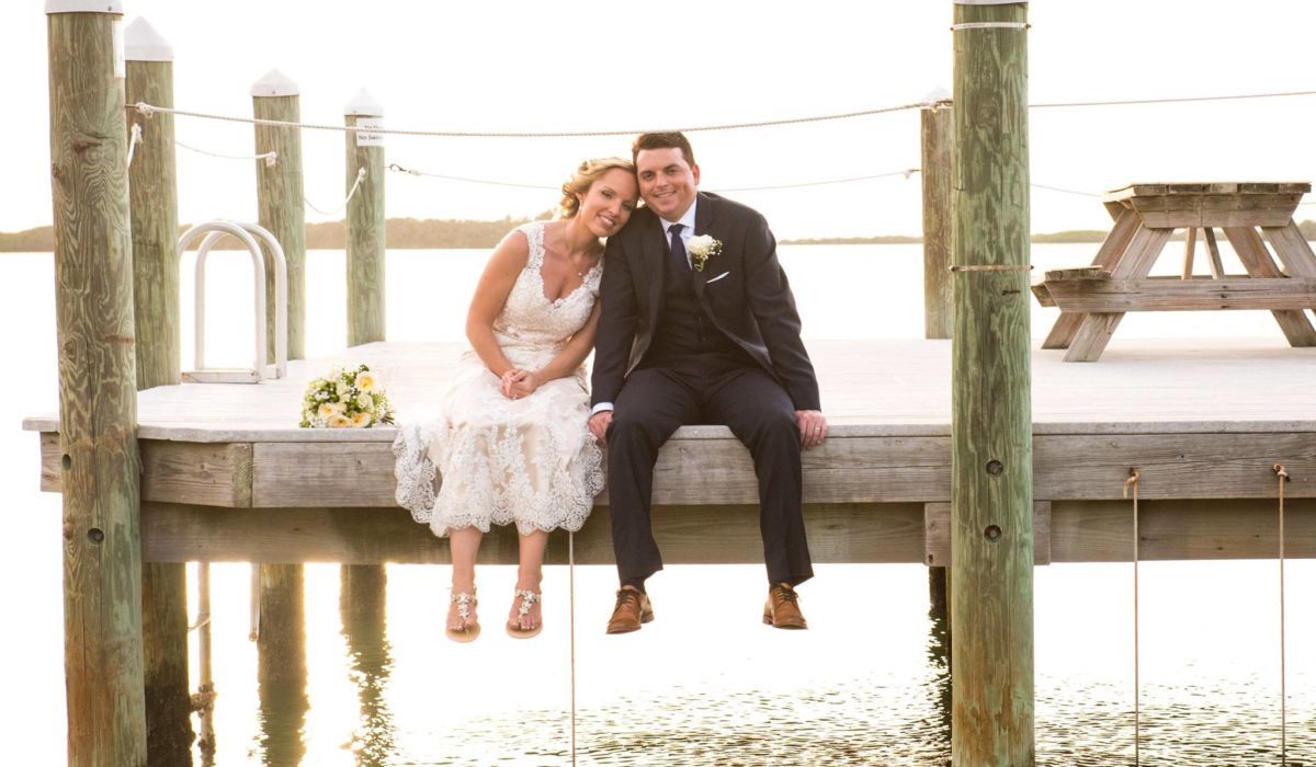 Bride and Groom Sitting on a Dock