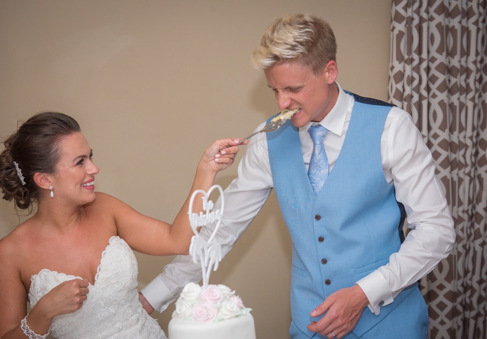 Wedding Cake Cutting Photo – Groom Eats the Cake